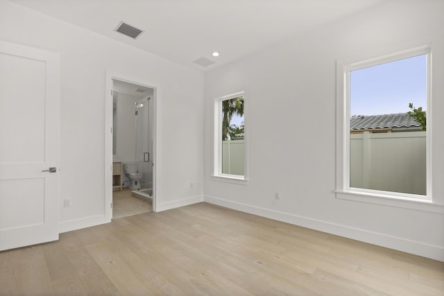 unfurnished bedroom with connected bathroom and light hardwood / wood-style flooring