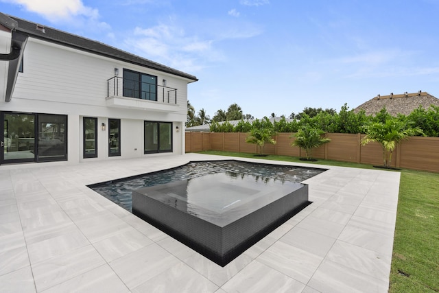 view of swimming pool featuring a patio and a hot tub