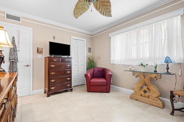 sitting room with ceiling fan, light tile patterned floors, and ornamental molding