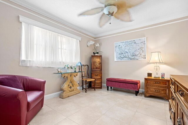 sitting room featuring ceiling fan, light tile patterned flooring, and ornamental molding