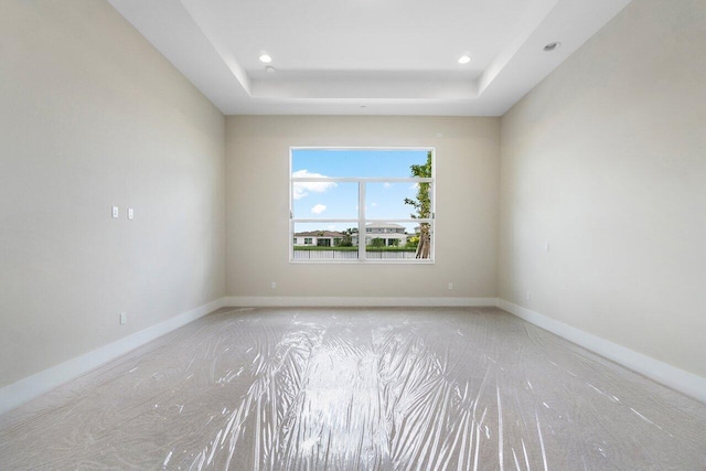 spare room with a raised ceiling