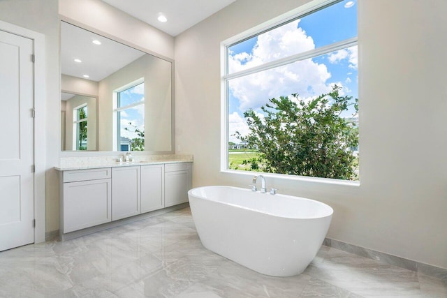 bathroom with a washtub and vanity