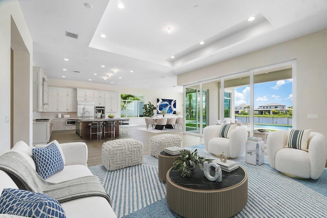 living room featuring hardwood / wood-style floors and a raised ceiling