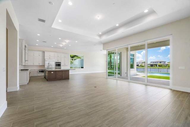 unfurnished living room featuring a raised ceiling