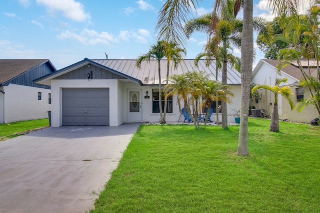 view of front facade featuring a garage, central AC, and a front lawn