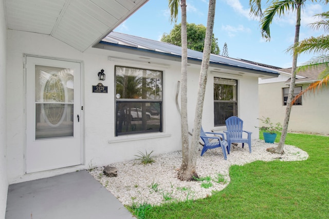 entrance to property featuring a lawn