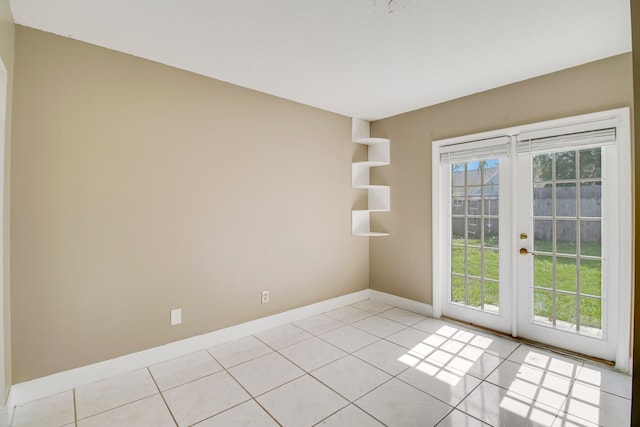 empty room featuring light tile patterned flooring, french doors, and a wealth of natural light