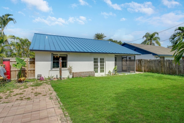 back of property featuring french doors and a yard