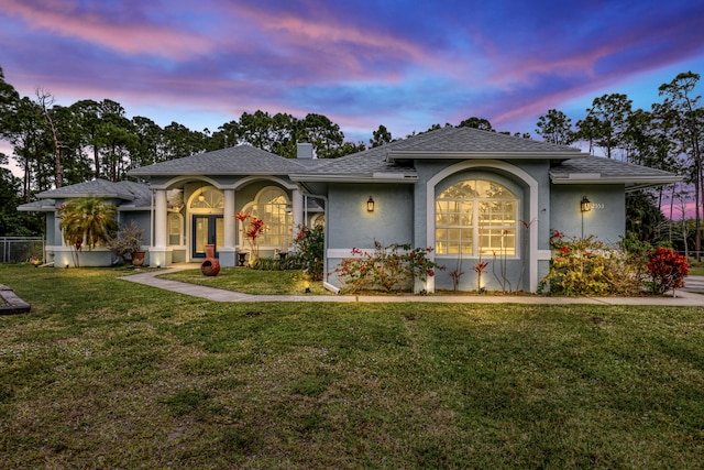 view of front of property with a yard and french doors