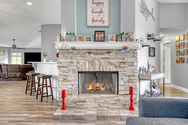 living room featuring a fireplace, ceiling fan, and lofted ceiling