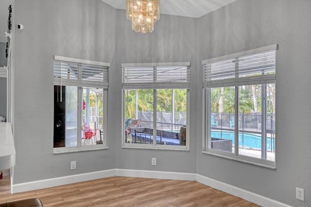 spare room featuring hardwood / wood-style floors and an inviting chandelier