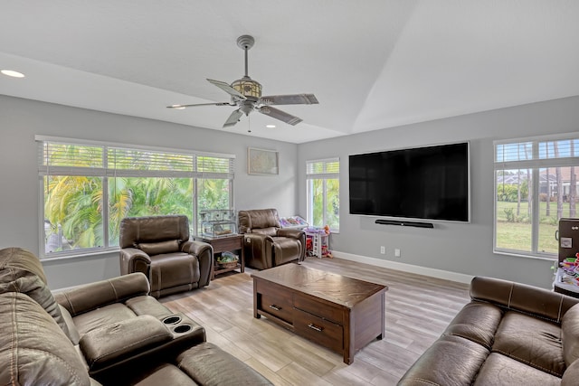 living room with ceiling fan, a healthy amount of sunlight, lofted ceiling, and light hardwood / wood-style flooring