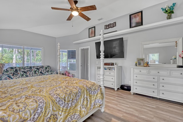 bedroom with ceiling fan, lofted ceiling, and light wood-type flooring