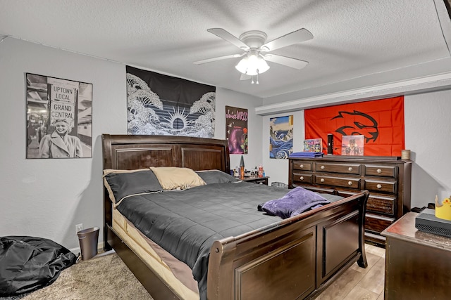 bedroom with ceiling fan and a textured ceiling