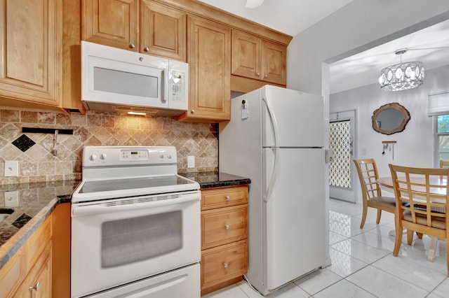 kitchen with a notable chandelier, tasteful backsplash, white appliances, light tile patterned floors, and dark stone counters