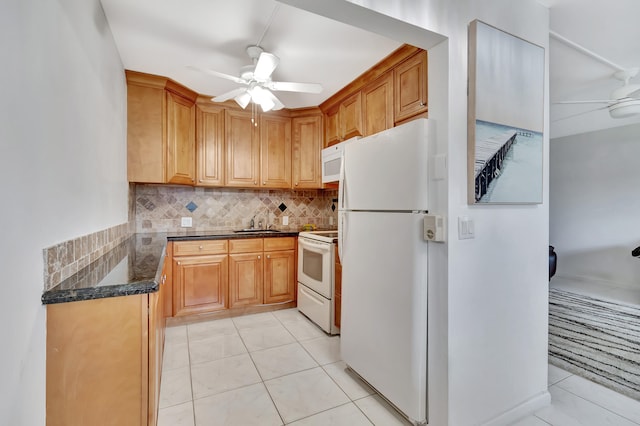 kitchen featuring dark stone counters, ceiling fan, tasteful backsplash, white appliances, and light tile patterned floors