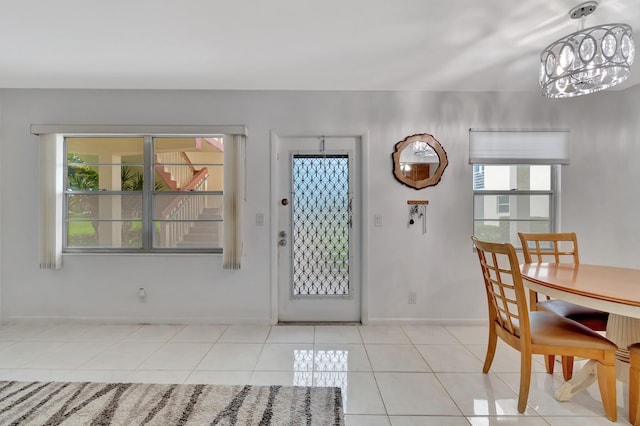 foyer entrance with a notable chandelier and light tile patterned floors