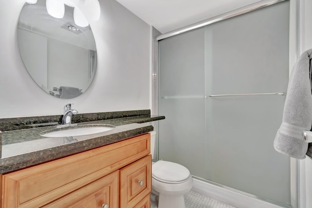 bathroom with vanity, walk in shower, tile patterned flooring, and toilet