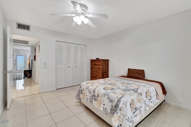 bedroom with light tile patterned floors, a closet, and ceiling fan