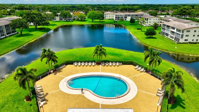 view of swimming pool featuring a water view and a lawn