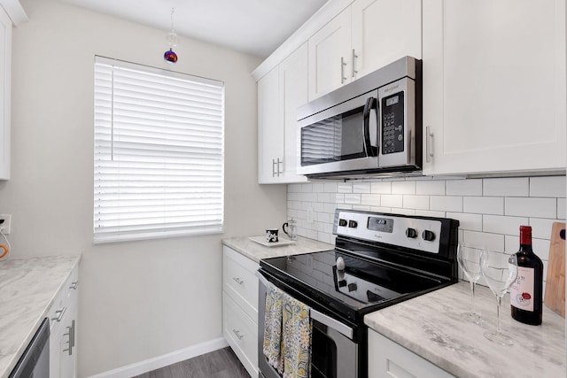 kitchen with light stone counters, white cabinetry, appliances with stainless steel finishes, and tasteful backsplash