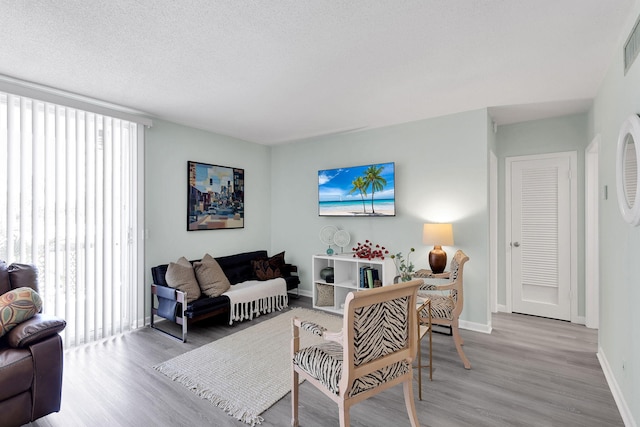 living room featuring light hardwood / wood-style floors and a textured ceiling