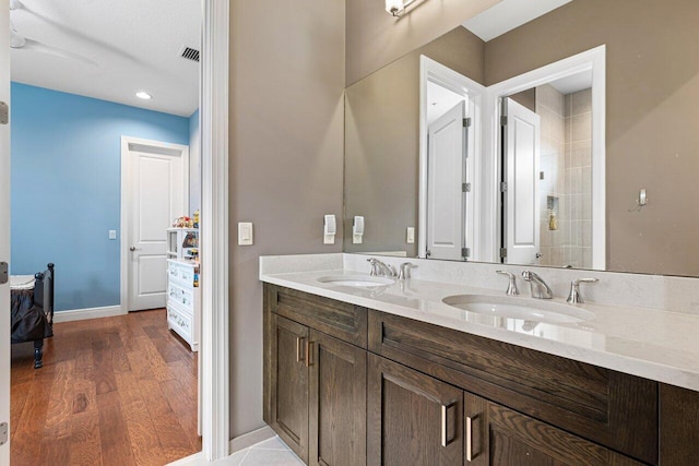 bathroom featuring wood-type flooring, double sink vanity, and ceiling fan