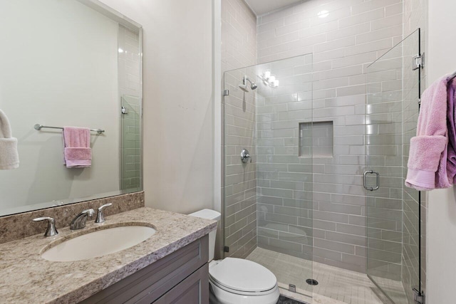 bathroom with vanity, walk in shower, and toilet