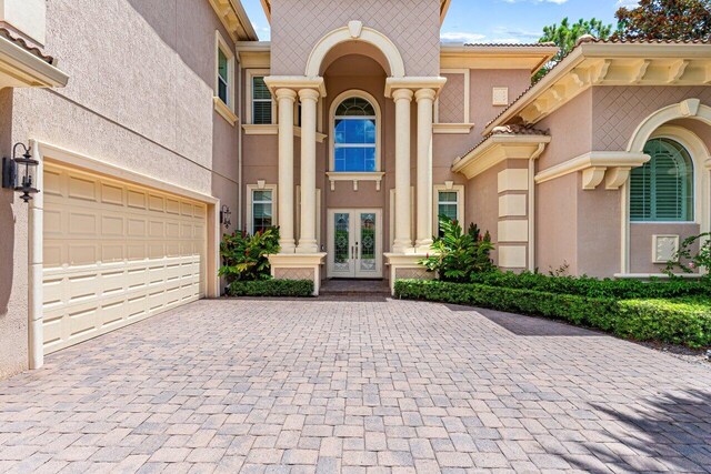 doorway to property with a garage and french doors