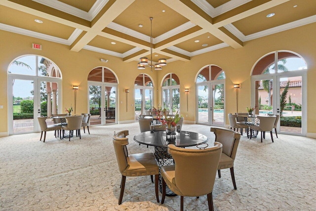 carpeted dining room featuring a towering ceiling, french doors, and coffered ceiling