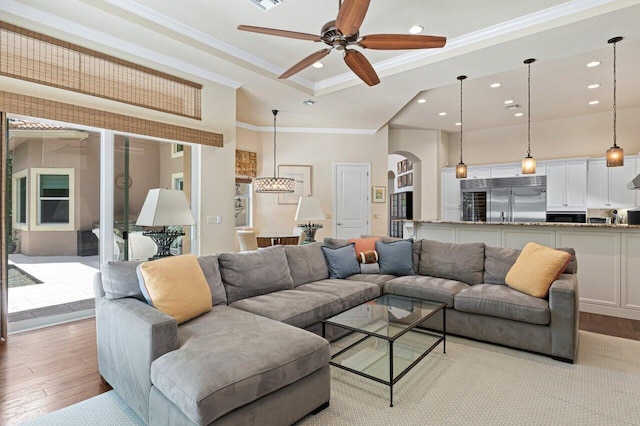 living room featuring hardwood / wood-style flooring, crown molding, and ceiling fan