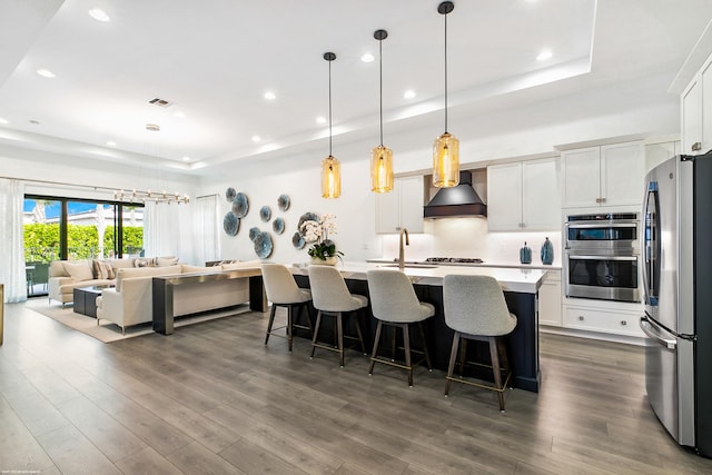 13173 Faberge Pl, Palm Beach Gardens, FL 33418 - kitchen with premium range hood, stainless steel appliances, a tray ceiling, a sink, and light countertops