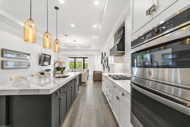 13173 Faberge Pl, Palm Beach Gardens, FL 33418 - kitchen featuring a sink, stainless steel appliances, white cabinetry, light wood finished floors, and light stone counters