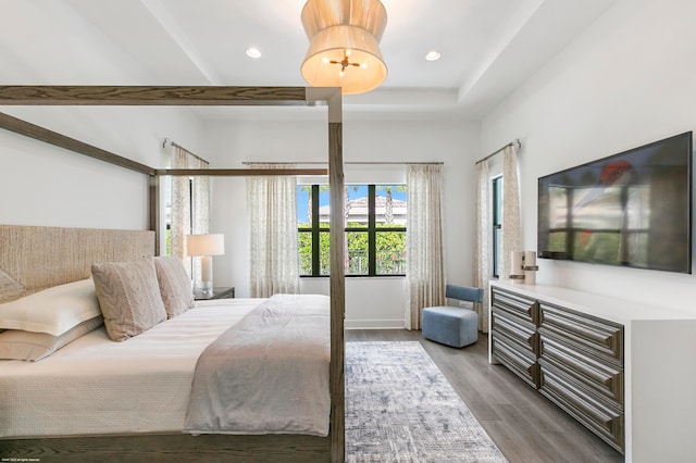 bedroom featuring hardwood / wood-style floors and a tray ceiling