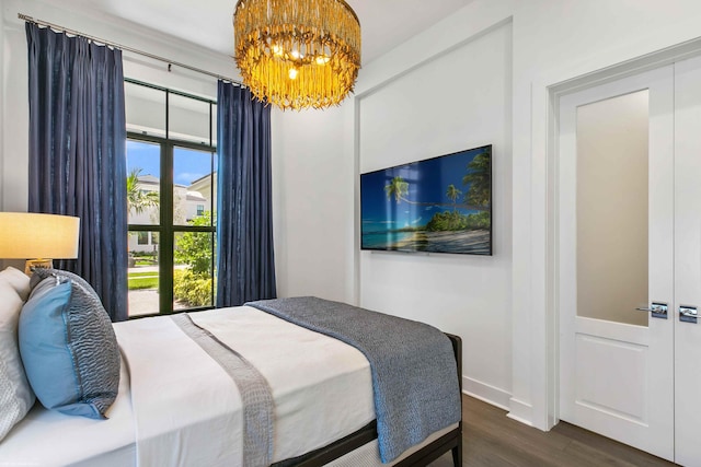 bedroom with dark hardwood / wood-style floors and a notable chandelier