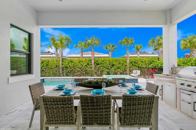 view of patio / terrace featuring area for grilling, sink, an outdoor kitchen, and a fenced in pool