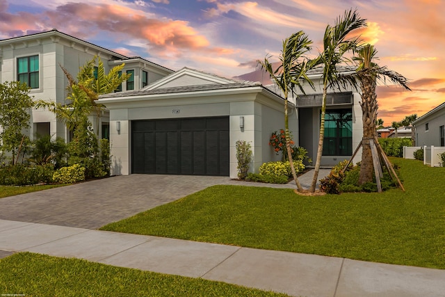 view of front of property with a garage and a lawn