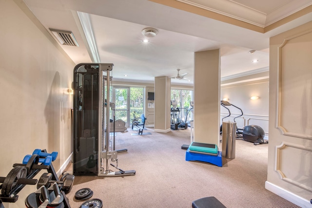 workout area featuring ceiling fan, carpet flooring, crown molding, and a tray ceiling