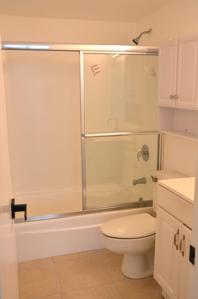 full bathroom featuring tile patterned flooring, vanity, toilet, and combined bath / shower with glass door