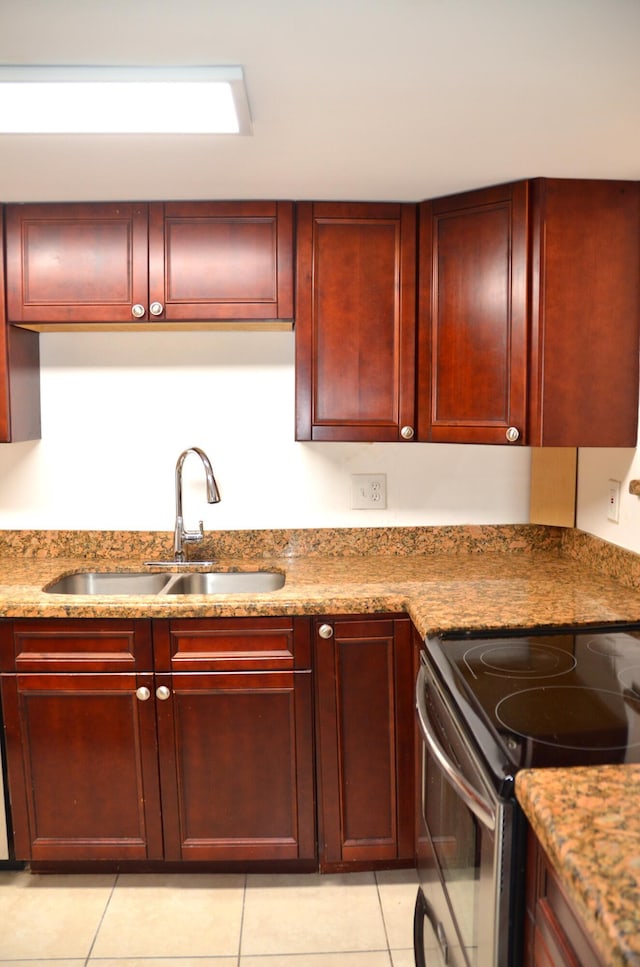 kitchen with stainless steel electric stove, sink, light tile patterned floors, and light stone counters