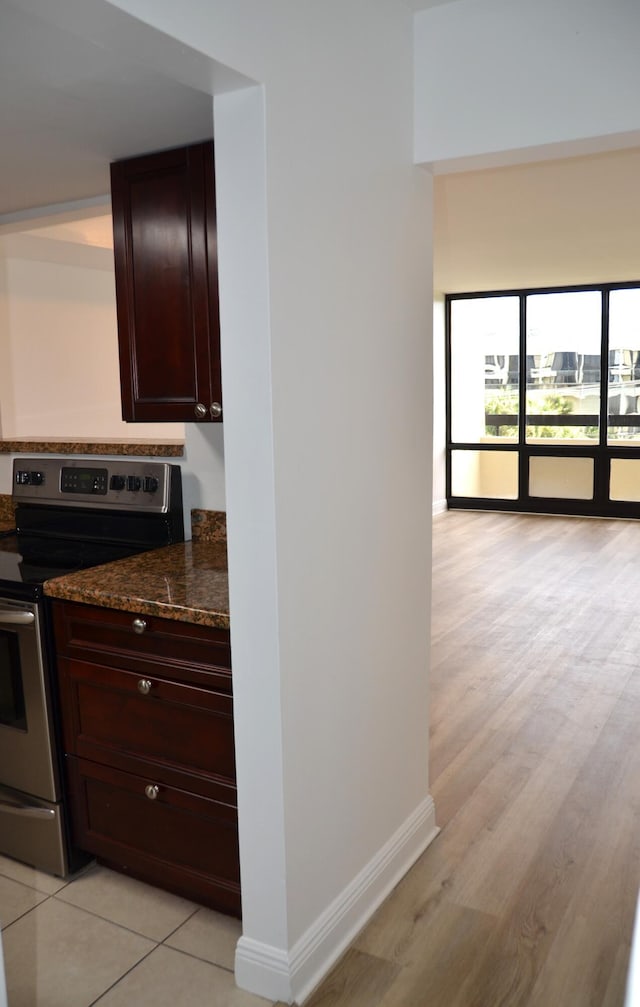 kitchen featuring dark stone counters and stainless steel electric stove