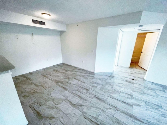 spare room with a textured ceiling and light tile flooring