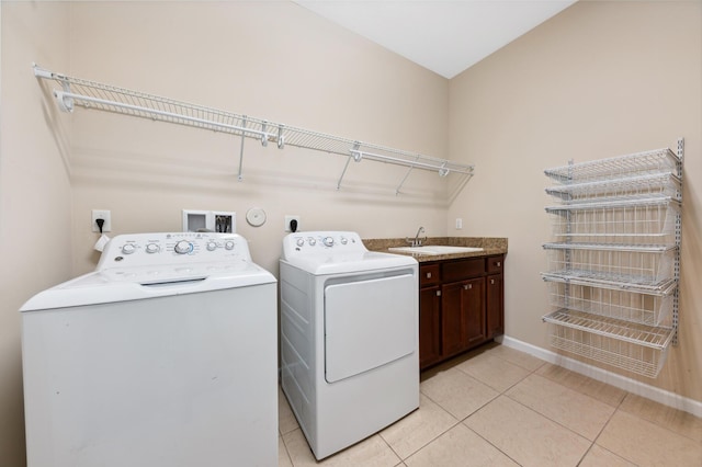 laundry room with cabinets, separate washer and dryer, sink, and light tile patterned floors