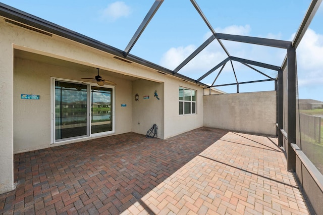 unfurnished sunroom with ceiling fan