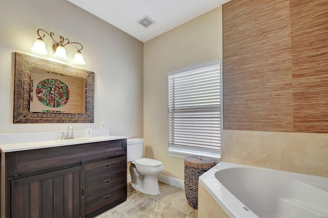 bathroom featuring a tub, vanity, and toilet