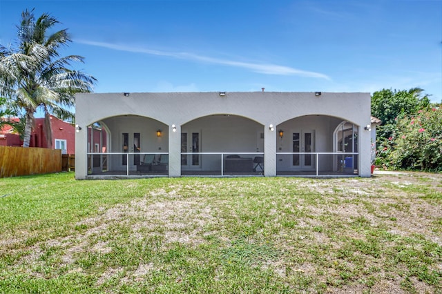 rear view of house with a yard and a sunroom