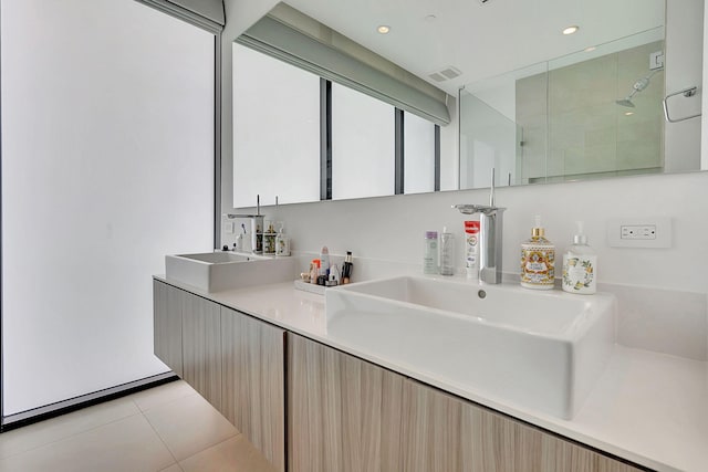 bathroom with tile patterned flooring, walk in shower, and vanity