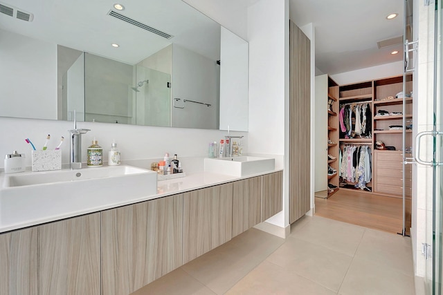 bathroom featuring a shower with door, vanity, and tile patterned floors