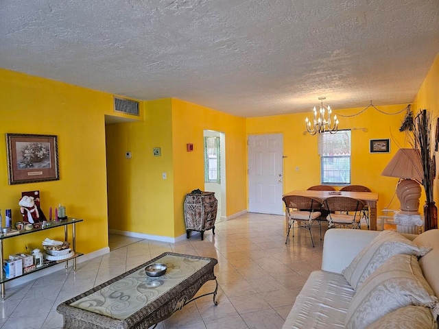 living room featuring tile floors, a notable chandelier, and a textured ceiling