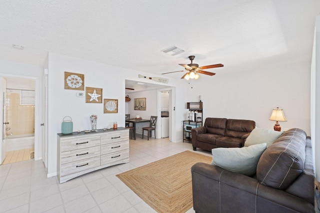 tiled living room with ceiling fan and a textured ceiling